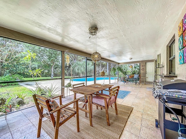 sunroom with ceiling fan and a swimming pool