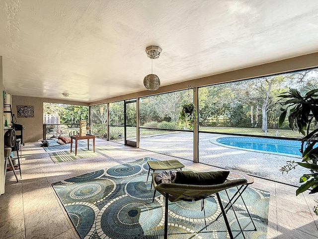 sunroom featuring a swimming pool