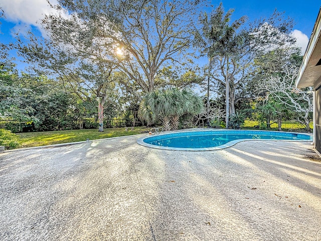 view of pool with a lawn