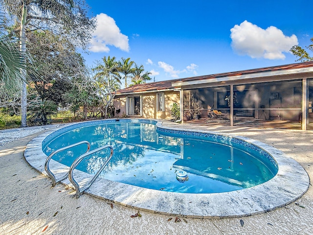 view of swimming pool featuring a patio and a sunroom