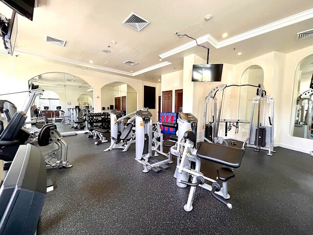 workout area featuring crown molding