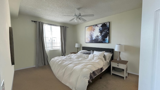 bedroom with ceiling fan, light colored carpet, and a textured ceiling