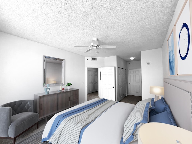 bedroom featuring dark carpet, ceiling fan, and a textured ceiling