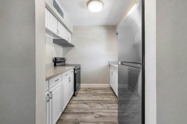 kitchen with white cabinets, stainless steel fridge, light hardwood / wood-style floors, and black / electric stove