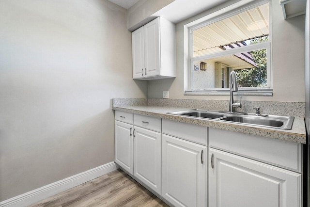 kitchen featuring sink, light hardwood / wood-style floors, and white cabinetry