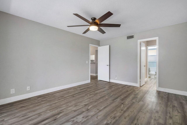 empty room featuring ceiling fan, dark hardwood / wood-style floors, and a textured ceiling