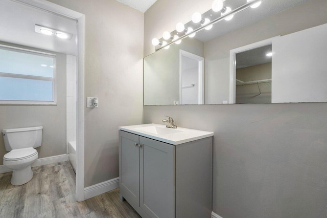 full bathroom featuring washtub / shower combination, vanity, toilet, and hardwood / wood-style flooring