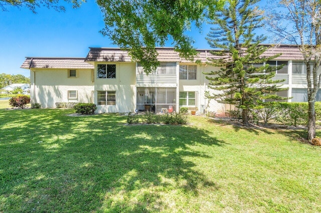 rear view of property featuring a lawn