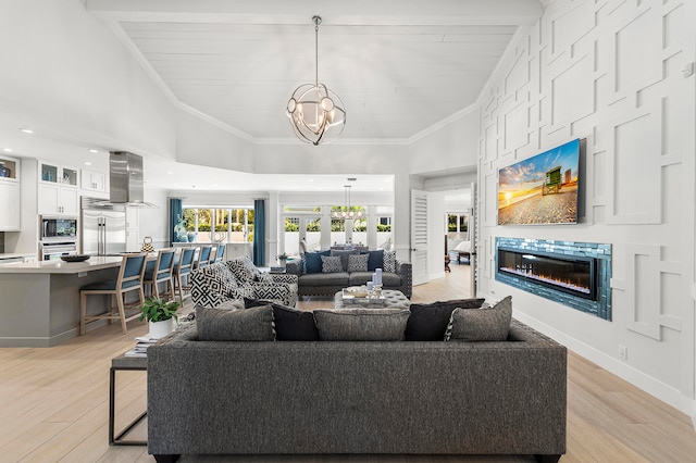 living room with light hardwood / wood-style flooring, a notable chandelier, and ornamental molding