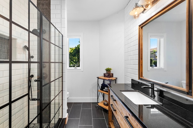 bathroom with tile floors, vanity, toilet, and walk in shower