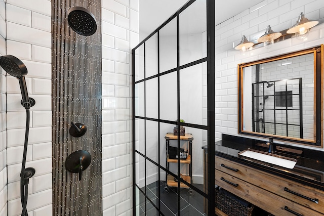 bathroom with tile walls, large vanity, and a tile shower