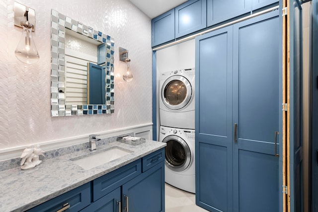 laundry room featuring sink and stacked washer / drying machine