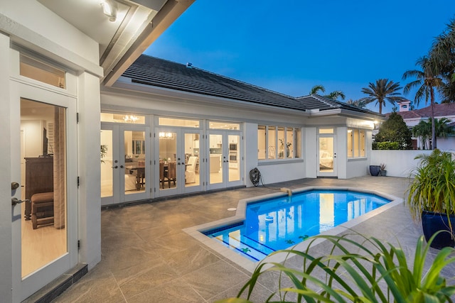 view of swimming pool with french doors and a patio