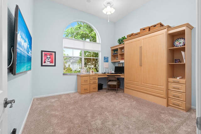 office space featuring light carpet and a high ceiling