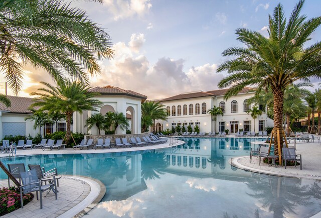 pool at dusk with a patio area