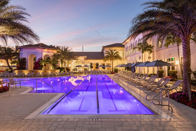 pool at dusk with a patio area