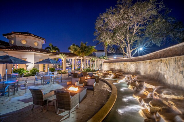 patio at night featuring an outdoor fire pit