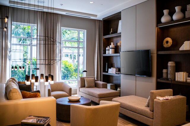 living room featuring plenty of natural light, built in features, and light wood-type flooring