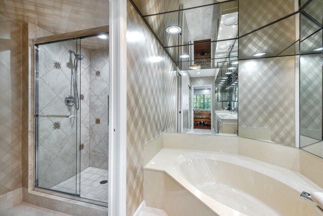 bathroom featuring large vanity and plus walk in shower