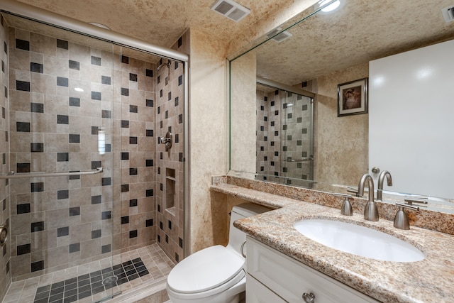 bathroom featuring oversized vanity, toilet, and a shower with shower door