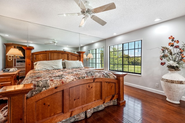 bedroom featuring dark hardwood / wood-style floors, ceiling fan, and a textured ceiling