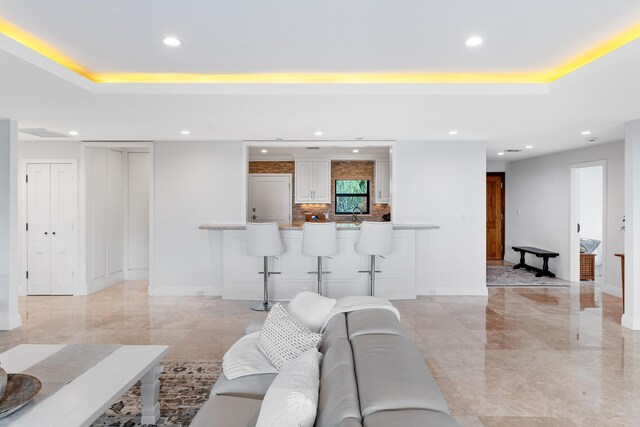 living room with plenty of natural light and a tray ceiling