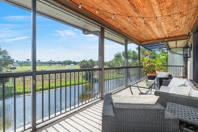 sunroom featuring a water view and wood ceiling