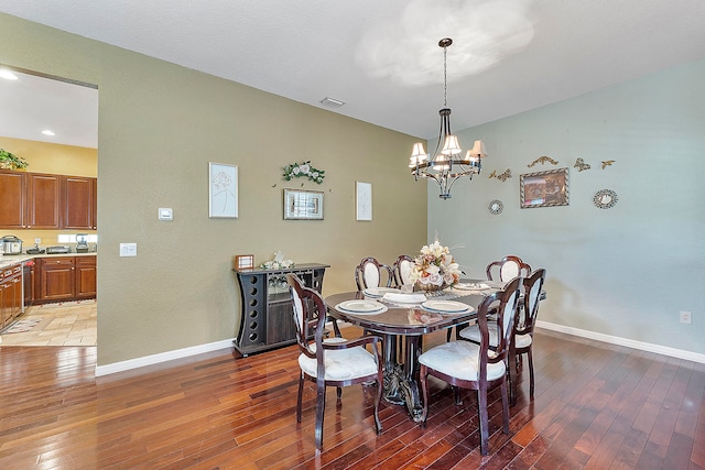 dining area featuring dark tile floors and an inviting chandelier