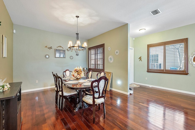 dining space featuring an inviting chandelier, dark hardwood / wood-style flooring, and a textured ceiling