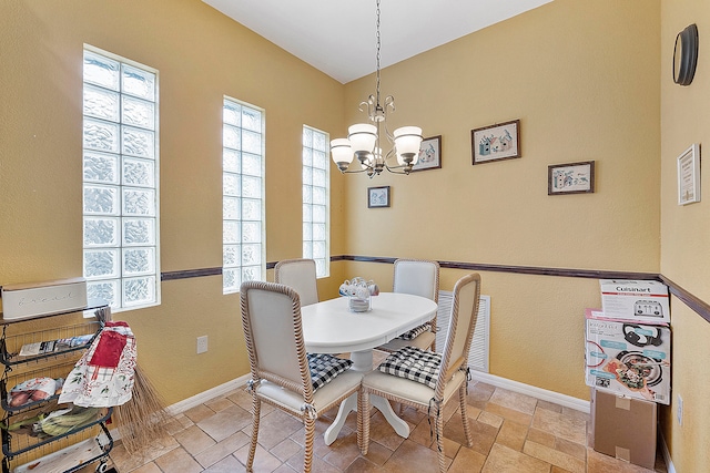 dining room with a chandelier and light tile floors