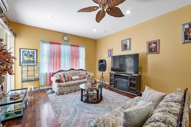 living room featuring ceiling fan and dark hardwood / wood-style floors