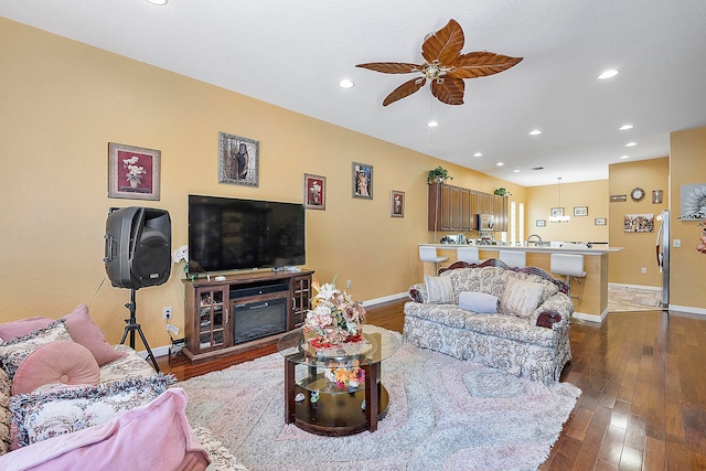 living room with ceiling fan, sink, and dark hardwood / wood-style flooring