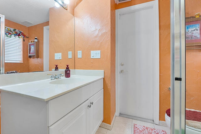 bathroom featuring tile floors, toilet, oversized vanity, and a textured ceiling