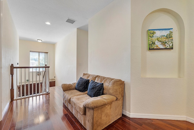 sitting room featuring a textured ceiling and dark hardwood / wood-style flooring