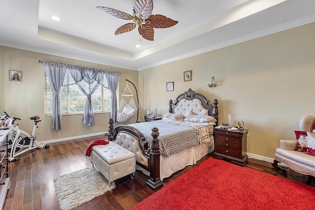 bedroom with ornamental molding, dark hardwood / wood-style flooring, ceiling fan, and a raised ceiling