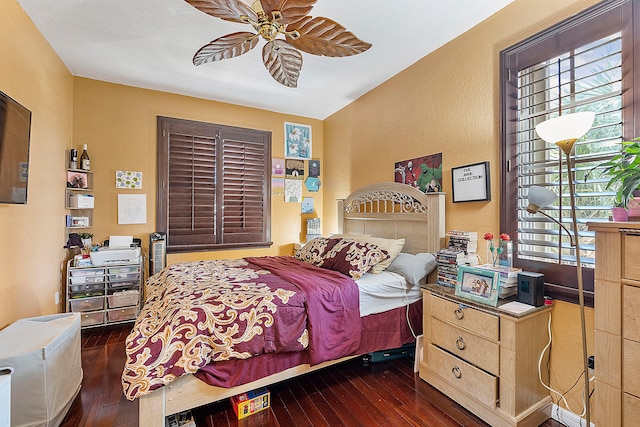 bedroom with dark hardwood / wood-style flooring and ceiling fan