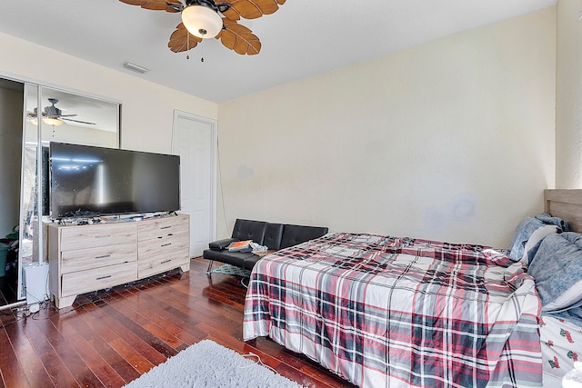 bedroom with a closet, ceiling fan, and dark wood-type flooring