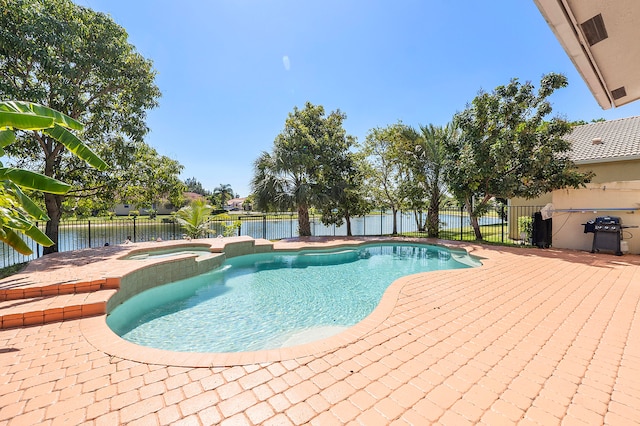 view of swimming pool with an in ground hot tub and a grill