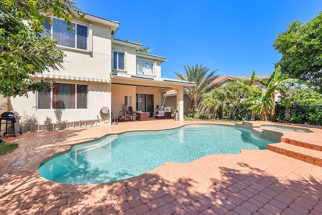 view of swimming pool featuring a patio area, grilling area, and an in ground hot tub