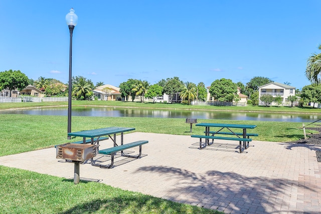 view of home's community with a lawn and a water view