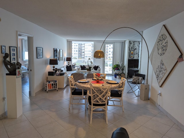 dining room featuring a textured ceiling, floor to ceiling windows, and light tile patterned floors