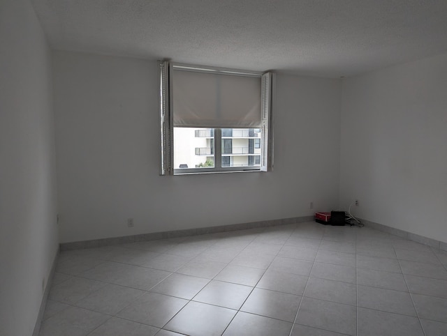 tiled spare room with a textured ceiling