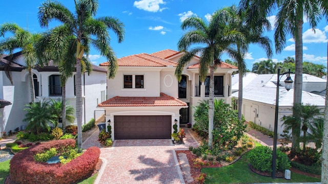 mediterranean / spanish house with a tiled roof, decorative driveway, and stucco siding