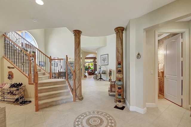 stairway with arched walkways, decorative columns, and baseboards