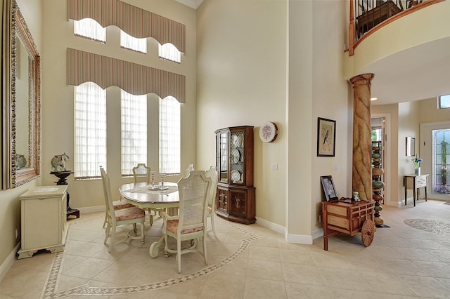 dining area featuring plenty of natural light, a high ceiling, and decorative columns