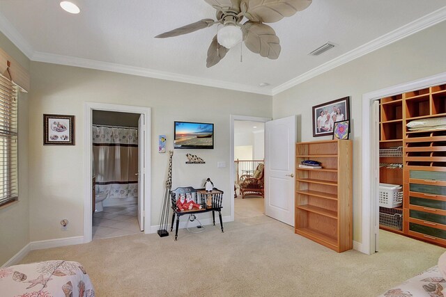 bedroom with ensuite bath, ornamental molding, and light colored carpet