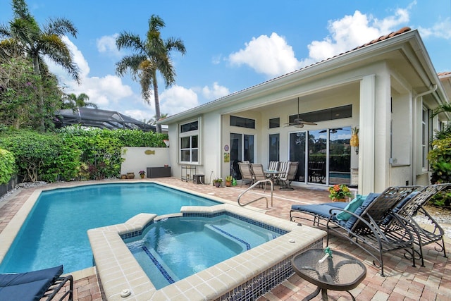 view of swimming pool featuring ceiling fan, a patio area, and an in ground hot tub