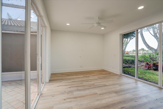 spare room with plenty of natural light, light hardwood / wood-style floors, and ceiling fan