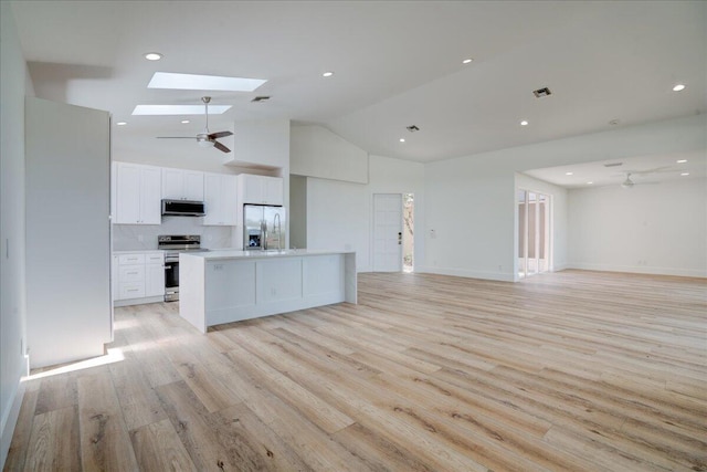 kitchen featuring ceiling fan, stainless steel appliances, light hardwood / wood-style floors, white cabinets, and a skylight