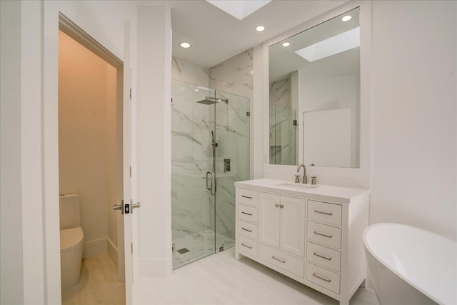 full bathroom featuring a skylight, vanity, toilet, and independent shower and bath